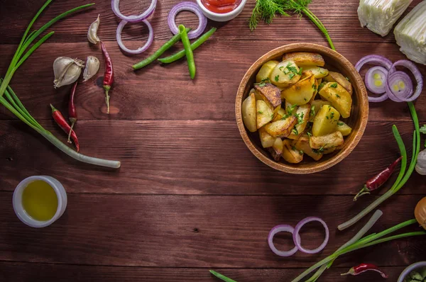 Kavrulmuş patates sebze ve otlar ahşap arka plan, üstten görünüm üzerinde. Yakın çekim — Stok fotoğraf