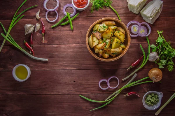 Batatas assadas com legumes e ervas em um fundo de madeira, vista superior. Close-up — Fotografia de Stock