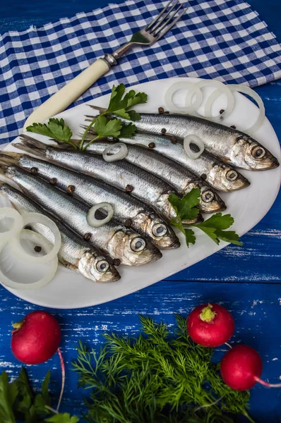 Herring fish with greens on a wooden blue background. Top view. Close-up — Stock Image Herring fish with greens on a wooden blue background. Top view. Close-up Royalty Free Stock Photos