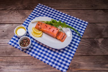 Somon steak, tereyağı, biber, limon ve Yeşiller plaka ahşap rustik arka plan üzerinde. yakın çekim.