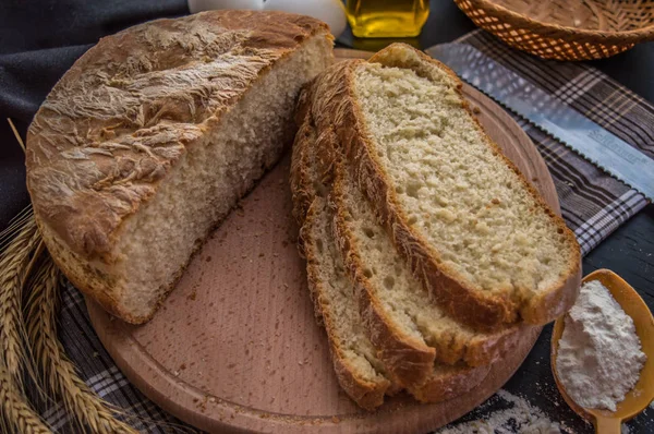 Pan recién horneado e ingredientes para hornear. Sobre una mesa de madera negra. .. Primer plano — Foto de Stock
