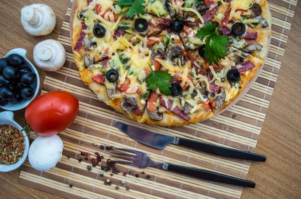 Пицца с ветчиной, грибами и оливками. Крупный план — стоковое фото