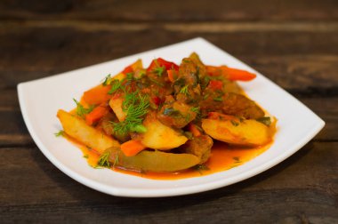 Patates, havuç, turşu, domates ve biber ile güveç. Azu beyaz bir kare plaka üzerinde Tartarian tarafından. Ahşap rustik arka plan. Üstten Görünüm. Yakın çekim
