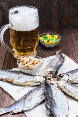 Kurutulmuş balık, hamamböceği ile bir bardak soğuk bira ahşap tablo