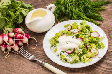 Turp, marul, ıspanak ve ekşi krema ahşap bir masa üzerinde salatası. Yakın çekim