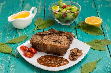 Sığır eti biftek orta Barbekü soslu ızgarada pişmiş. ahşap arka plan