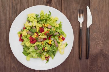 Gelen sığır dili, Çince lahana, biber, Mısır, maydanoz ve fesleğen salata. Ahşap arka plan. Üstten Görünüm