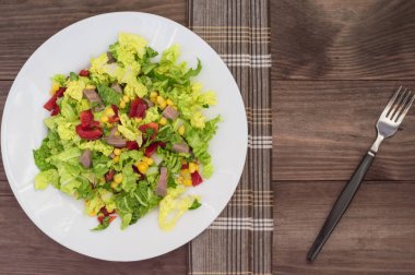 Gelen sığır dili, Çince lahana, biber, Mısır, maydanoz ve fesleğen salata. Ahşap arka plan. Üstten Görünüm