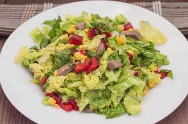 Gelen sığır dili, Çince lahana, biber, Mısır, maydanoz ve fesleğen salata. Ahşap arka plan. Üstten Görünüm