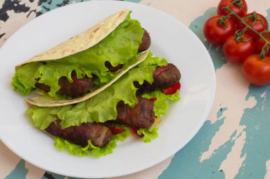 Tortilla pastırma ve otlar sarılmış etli. Ahşap arka plan. Üstten Görünüm. Yakın çekim