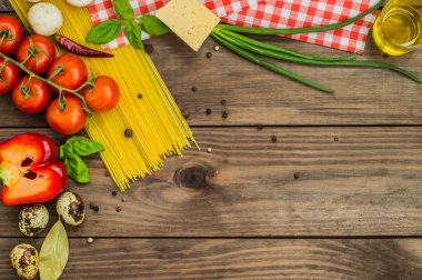 Kuru pasta Domates, otlar ve baharatlar için ahşap zemin, üstten görünüm üzerine domates sosu ile