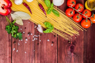 Kuru pasta Domates, otlar ve baharatlar için ahşap zemin, üstten görünüm üzerine domates sosu ile