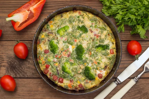 Spanish tortilla in the pan. Wooden rustic table. Top view