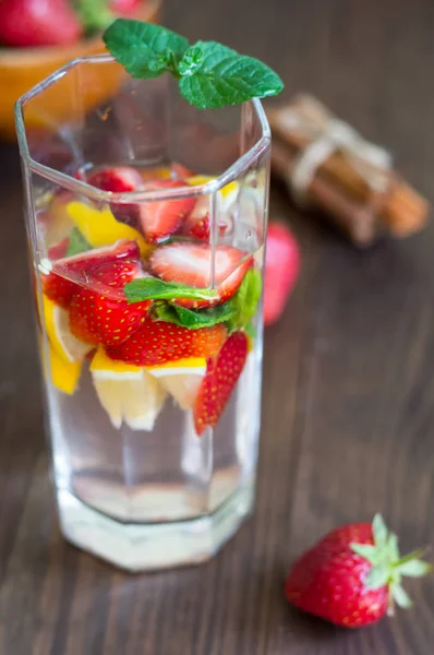 Citronnade fraîche aux fraises, menthe et glace sur une table en bois. Gros plan — Photo