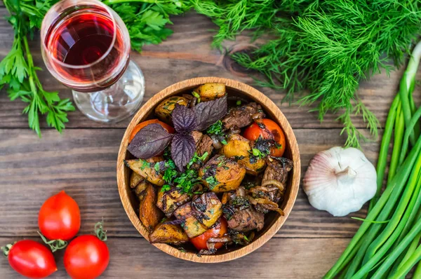 Viande rôtie avec pommes de terre, ojaxuri, chaud en géorgien et vin rouge sur une table en bois. Vue de dessus. Gros plan — Photo