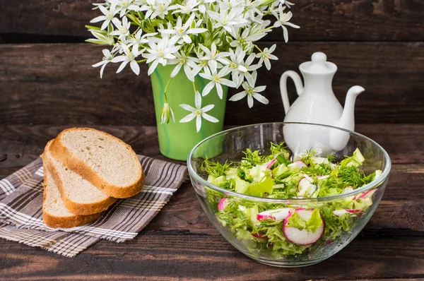 Salade met radijs, sla, spinazie en olijfolie op een houten tafel — Stockfoto