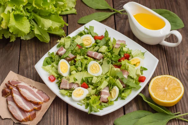 Salad dengan bayam, telur puyuh dan bacon. Meja kayu. Pemandangan bagus. Close-up — Stok Foto