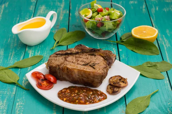 Bife de carne médio raro na grelha com molho de churrasco. fundo de madeira — Fotografia de Stock