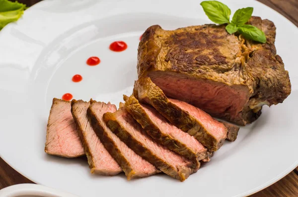 สเต็กเนื้อวัวย่างกับซอสบาร์บีคิว โต๊ะไม้ ท็อปวิว ใกล้ชิด — ภาพถ่ายสต็อก