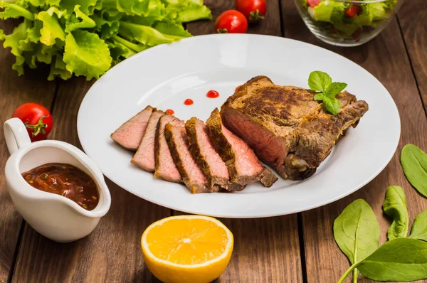 珍しい牛肉ステーキ媒体のグリル バーベキュー ソース。木製のテーブル。平面図です。クローズ アップ — ストック写真