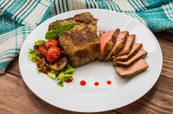 Vzácné středně hovězí steak na grilu s barbecue omáčkou. Dřevěný stůl. Pohled shora. Detail — Stock fotografie