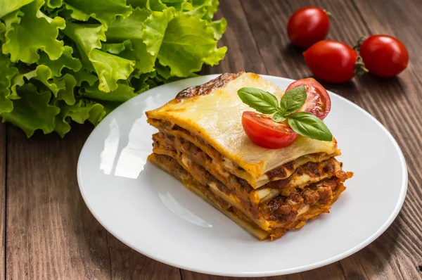 Lasanha, comida tradicional italiana em um fundo de madeira — Fotografia de Stock