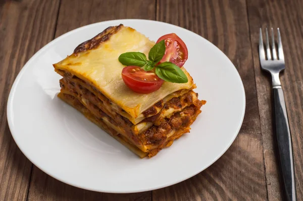 Lasanha, comida tradicional italiana em um fundo de madeira — Fotografia de Stock