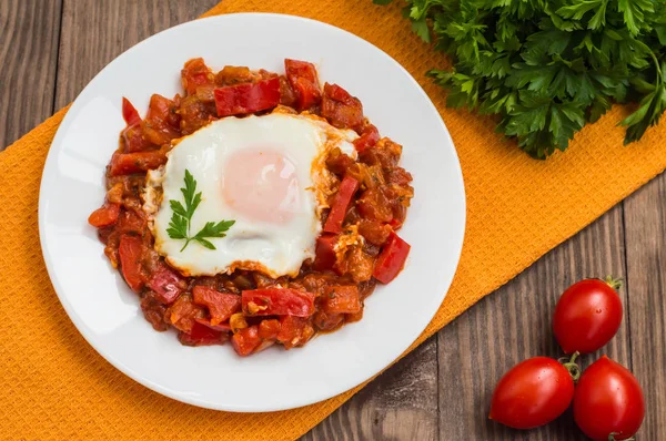 Shakshuka beyaz bir plaka üzerinde. Geleneksel Yahudi yemeği. Ahşap masa. Üstten Görünüm. Yakın çekim — Stok fotoğraf