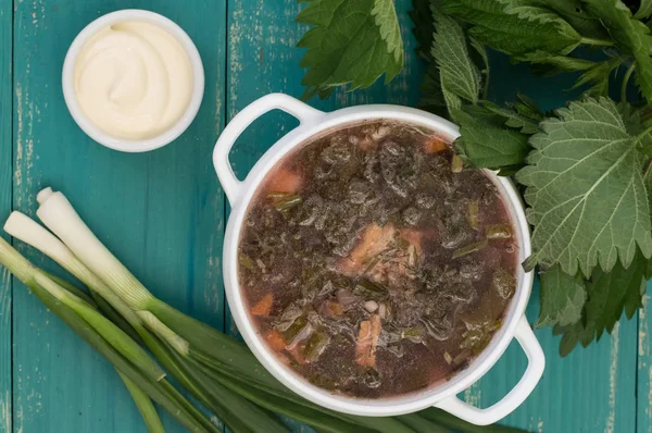 Borsch uit een brandnetel op houten tafel. Bovenaanzicht — Stockfoto