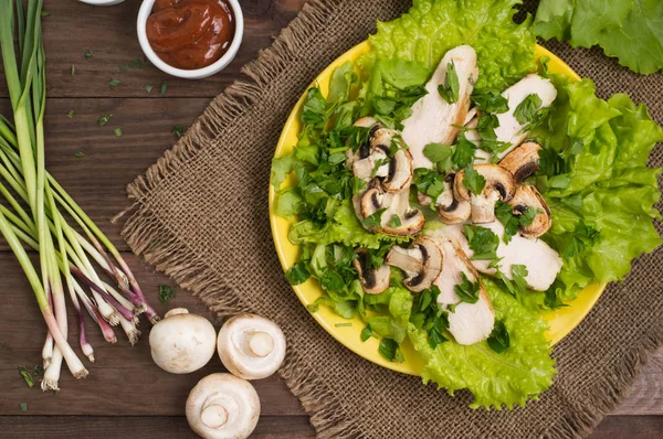 绿色沙拉配蘑菇和鸡肉。木制的背景。顶视图 — 图库照片