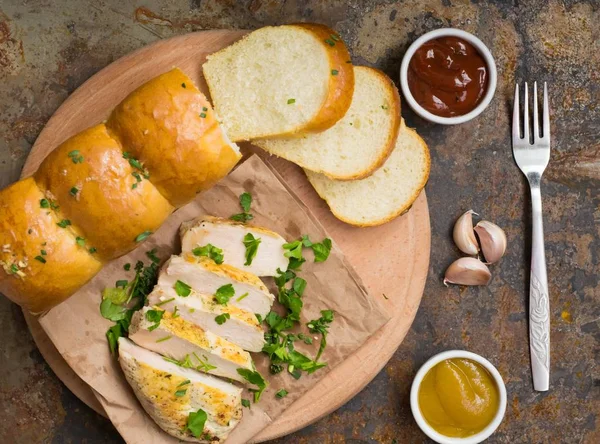 Vitlöksbröd med stekt kyckling, gröna och sås på en trä bakgrund. Ovanifrån. Närbild — Stockfoto