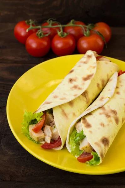 Tortilla with chicken, croutons, mozzarella, tomatoes, bell peppers, sauce and greens. Top view. Close-up — Stock Photo, Image