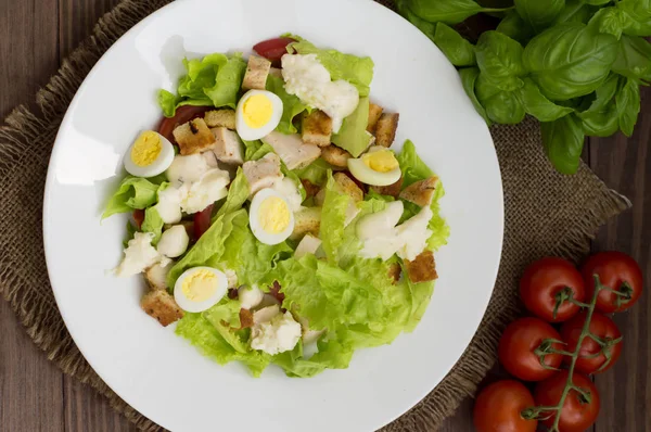 Insalata con ravanelli, rucola, pollo e uovo di quaglia su fondo di legno, vista dall'alto — Foto Stock