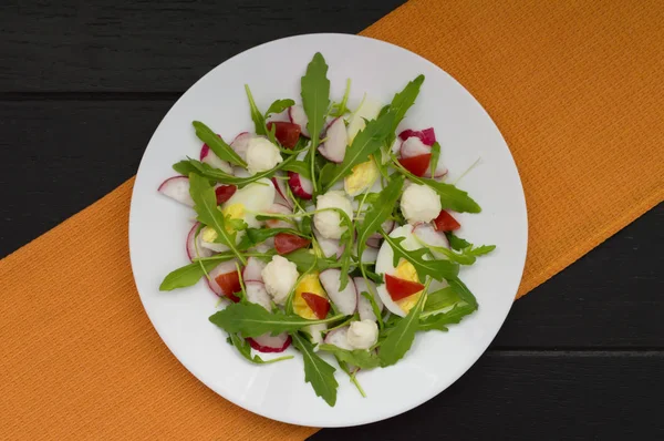 Salat mit Radieschen, Rucola, Huhn und Wachtelei auf Holzgrund, Draufsicht — Stockfoto
