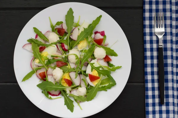 Salat mit Radieschen, Rucola, Huhn und Wachtelei auf Holzgrund, Draufsicht — Stockfoto