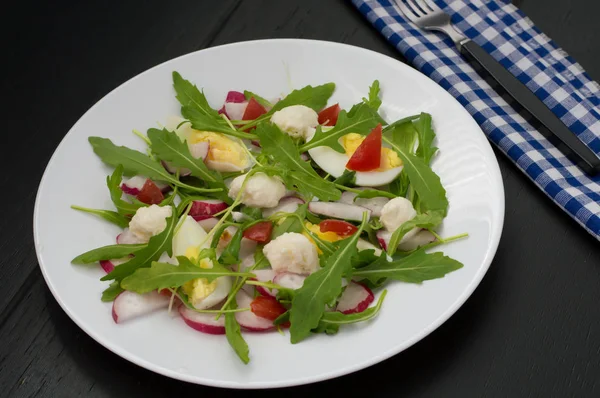 Салат с редиской, рукколой, курицей и перепелиным яйцом на деревянном фоне, вид сверху — стоковое фото