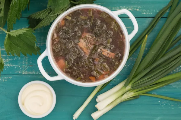 Borsch from a nettle on wooden table. Top view — Stock Image Borsch from a nettle on wooden table. Top view Stock Picture