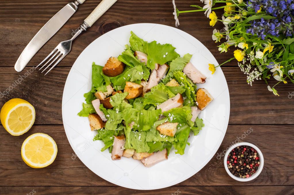 Salad of smoked chicken, croutons, lettuce and parmesan. Wooden rustic background. Top view. Close-up