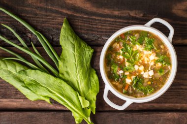 Yumurta ve onun yemek pişirmek için malzemeler ile yeşil çorbası. Ahşap arka plan