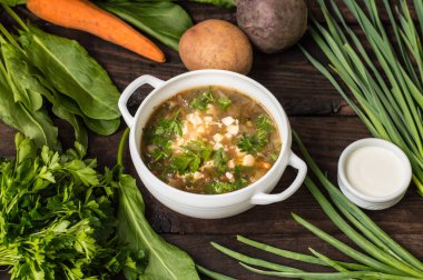 Yumurta ve onun yemek pişirmek için malzemeler ile yeşil çorbası. Ahşap arka plan. Üstten Görünüm. Yakın çekim