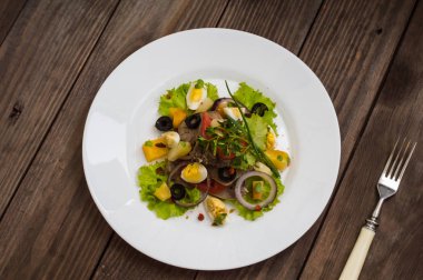 Ahşap arka plan üzerinde dil ile salata. Üstten Görünüm. Yakın çekim