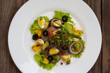 Ahşap arka plan üzerinde dil ile salata. Üstten Görünüm. Yakın çekim
