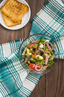 Ahşap arka plan üzerinde dil ile salata. Üstten Görünüm