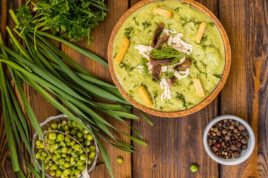 Çorba bezelye, eritilmiş peynir, kavrulmuş et, kruton ve otlar ile püre. Ahşap arka plan. Üstten Görünüm. Yakın çekim