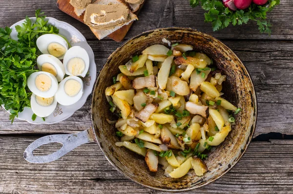 Τηγανιτές πατάτες σε λαρδί με βότανα σε ένα παλιό ξύλινο τραπέζι. Το Top view. Γκρο πλαν — Φωτογραφία Αρχείου