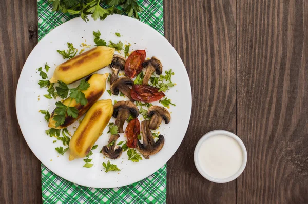 Kentang Zrazy diisi dengan jamur daging dan tomat panggang di piring putih. Latar belakang kayu. Pemandangan bagus. Close-up — Stok Foto