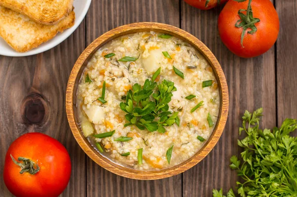 Vetemjölsgröt med kött tillagas på en brand i träplatta rustika bord. Ovanifrån — Stockfoto