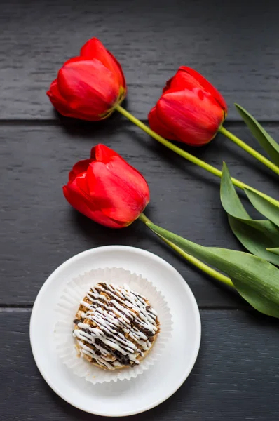 Kuchen mit Blumen. romantische Atmosphäre. schwarzer Holztisch. Ansicht von oben. Nahaufnahme — Stockfoto