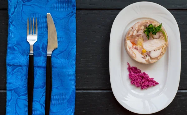 Aspik mit Fleisch und Meerrettich auf einem Holztisch — Stockfoto