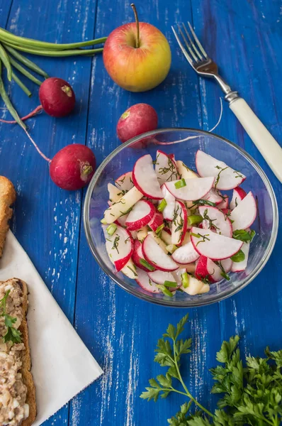 Sallad med rädisor, äpplen och gröna. Blå bakgrund — Stockfoto